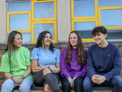 Photo of 4 students on a bench