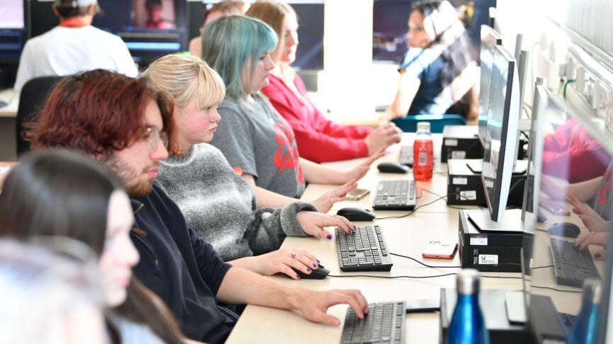 Film studies students working at computers editing films