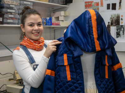 Fashion student standing with garment on mannequin