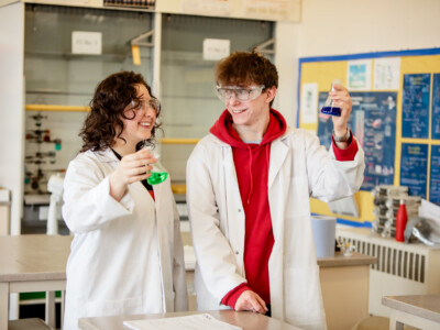 Male and female students in a practical chemistry lesson