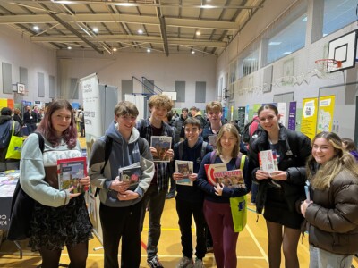 Students hold up the university prospectuses that they gathered at the Esher Sixth Form College's Higher Education Day Fair