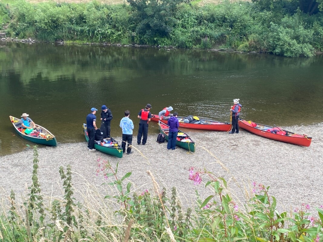 students canoes on shore