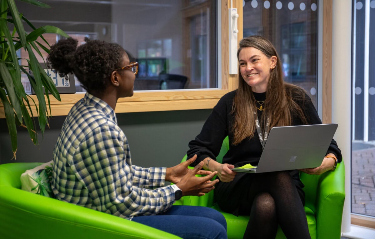 A female student and female teacher talking and smiling in the study centre