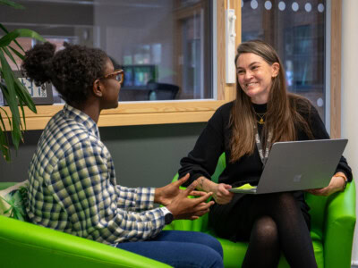 A female student and female teacher talking and smiling in the study centre