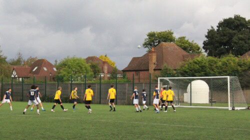 Photo of a football team playing outside near a goal