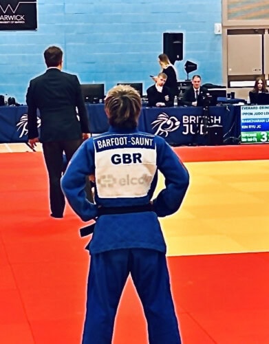 Judo student standing on competition mat with TEAM GB kit on