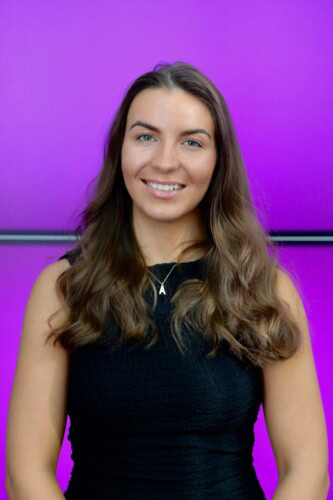 Portrait of a woman in a black dress against a purple background