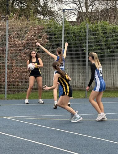 netballers about to throw the ball to another player attacking the goal area