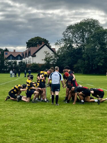 men's rugby team scrum building on the pitch