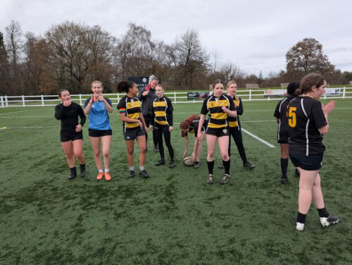 Women's rugby team walking off the pitch after a game look triumphant