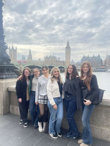 group of female students posing by the Thames opposite Westminster