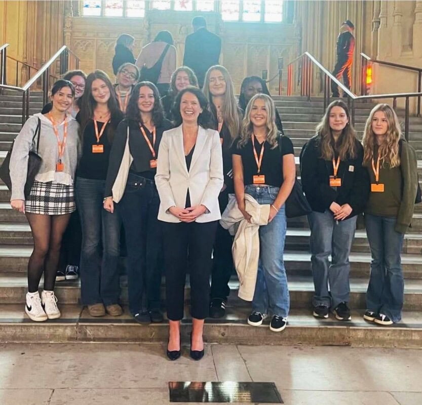 Female Politics students standing on the steps of Parliament with Monica Harding