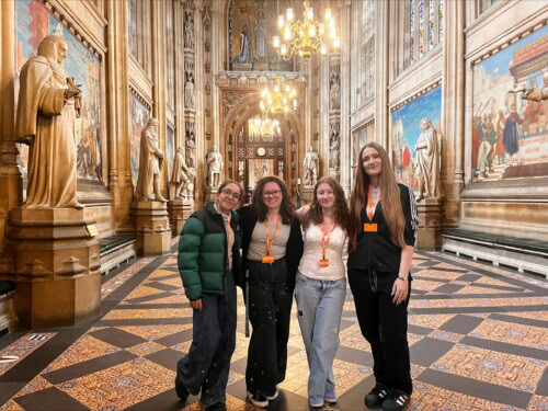 Four female students posing inside Parliament